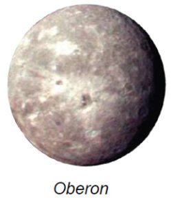 The image displays a celestial body, Oberon, which is one of Uranus’s moons. It appears as a nearly perfect sphere in the image. The surface is a mixture of light and dark patches, indicating craters or varying terrain. The dominant color is a muted gray, with lighter, almost white areas highlighting surface features, and some darker spots suggesting larger craters. The texture looks rugged and uneven, characteristic of a heavily cratered satellite.