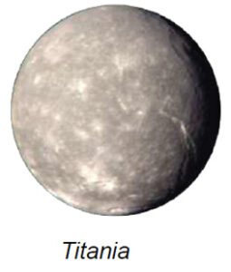 The image depicts Titania, one of Uranus's moons. Titania appears as a spherical celestial body with a predominantly gray surface. The surface is marked with numerous small craters and lighter patches scattered across its surface, giving it a textured appearance. A few larger and more prominent craters are visible, along with some linear features that may indicate tectonic activity. The lighting creates a subtle shadow on the lower right, adding depth to the image.