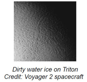 The image depicts a surface on Neptune's moon, Triton, showing an expansive area covered with complex patterns and textures. The surface appears mottled with various shades of gray, with lighter areas possibly indicating ice or different material compositions. Prominent, winding, and interwoven lines traverse the image, creating a network of patterns resembling natural fissures or formations on a crust. The left side is lighter, suggesting an external light source creating shadows and highlighting the topographical details, while the right side fades into darkness, suggesting the curvature of the moon or shadowing.