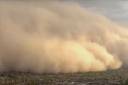 a sandstorm moving towards a city